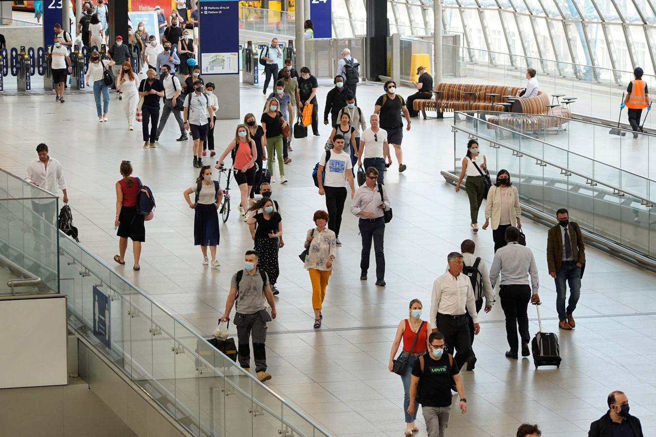 Viajeros con y sin mascarillas llegan a la estación de Waterloo en Londres. 