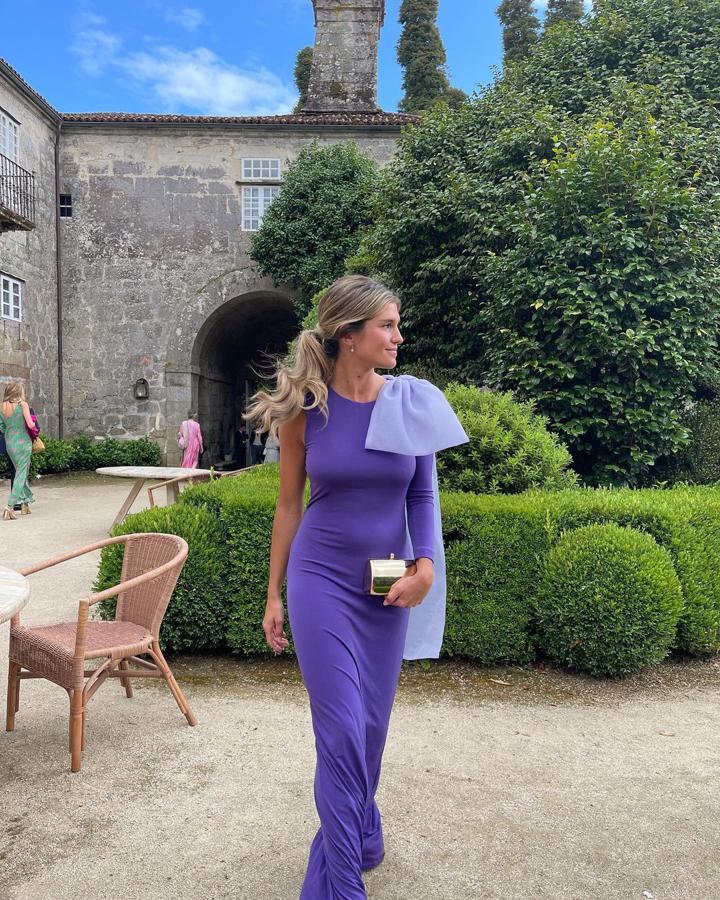 Marta Vidaurreta con vestido con mangas asimétricas en color lila con gran lazada en un hombro de la firma española Moosy.