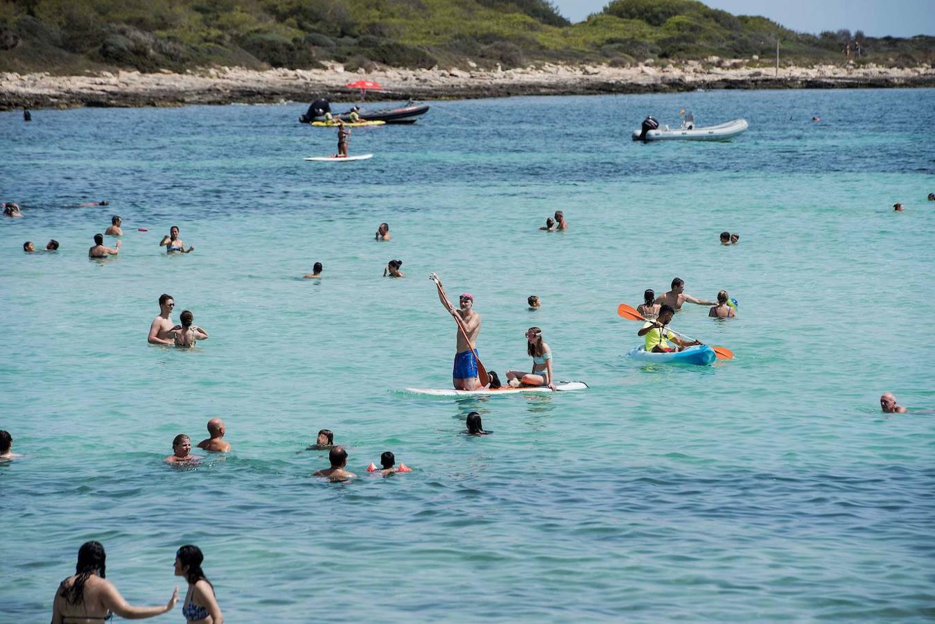 Varios bañistas disfrutan de una soleada jornada en la playa de Punta Prima de Menorca, este sábado. 