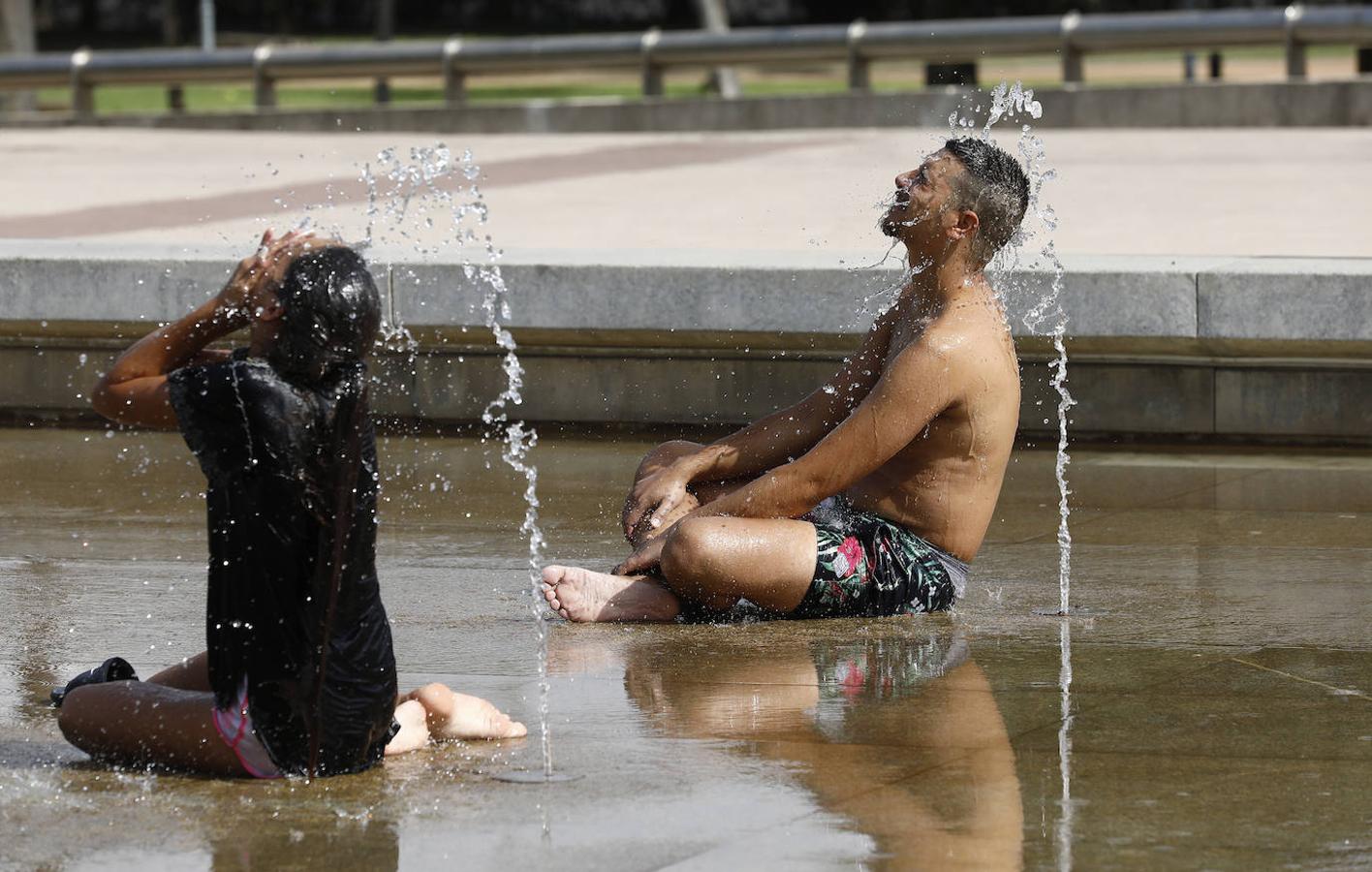 Dos turistas se refrescan en una fuente de Córdoba durante la ola de calor. 