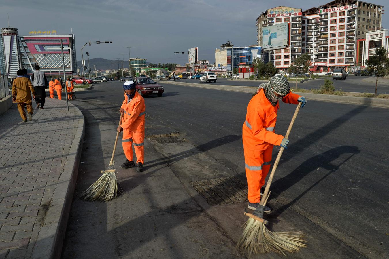 Trabajadores afganos limpian una carretera en Kabul. 