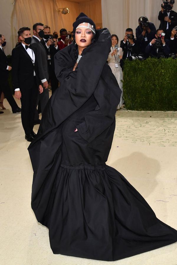 Rihanna - Alfombra roja de la Gala MET 2021. También eligió  Balenciaga y el color negro con un voluminoso vestido-capa con volantes XXL.