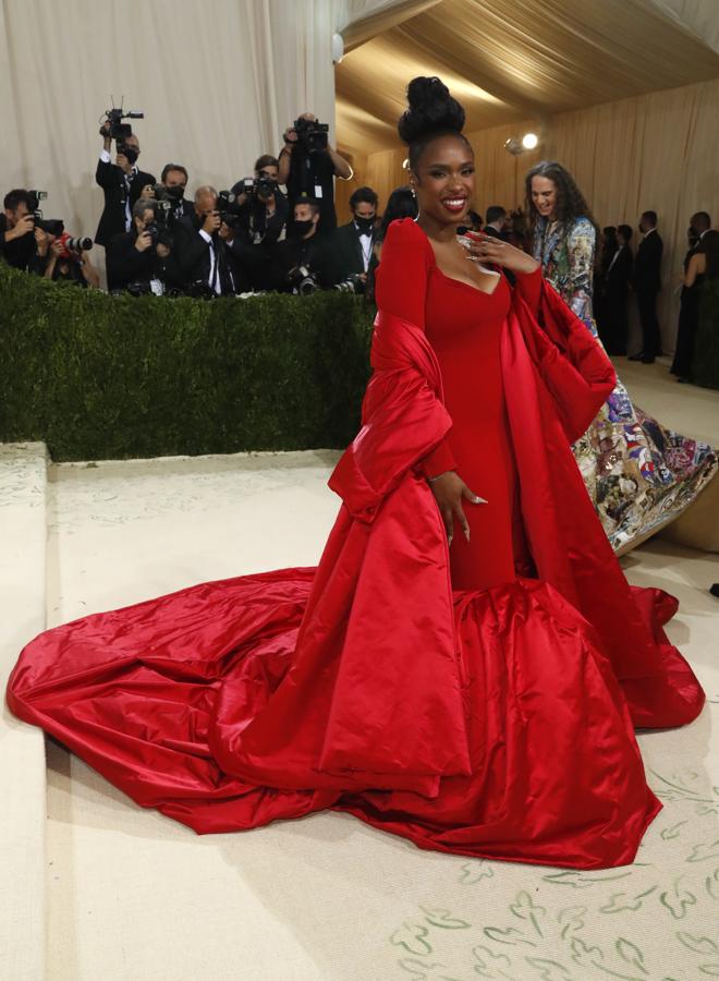Jennifer Hudson - Alfombra roja de la Gala MET 2021. Muy llamativa con un imponente vestido rojo con gran cola de AZ Factory compuesto de un escote bardot, mangas farol y una capa satinada como complemento principal.
