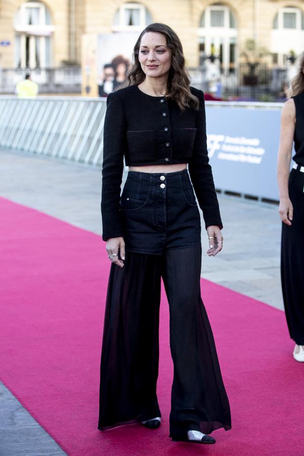 Marion Cotillard, simplicidad en clave denim. La actriz francesa lució un look algo más desenfadado, también de Chanel, compuesto por unos pantalones acampanados, vaqueros en la parte superior y de gasa en el bajo, con una torera de tweed negra y salones bicolor.