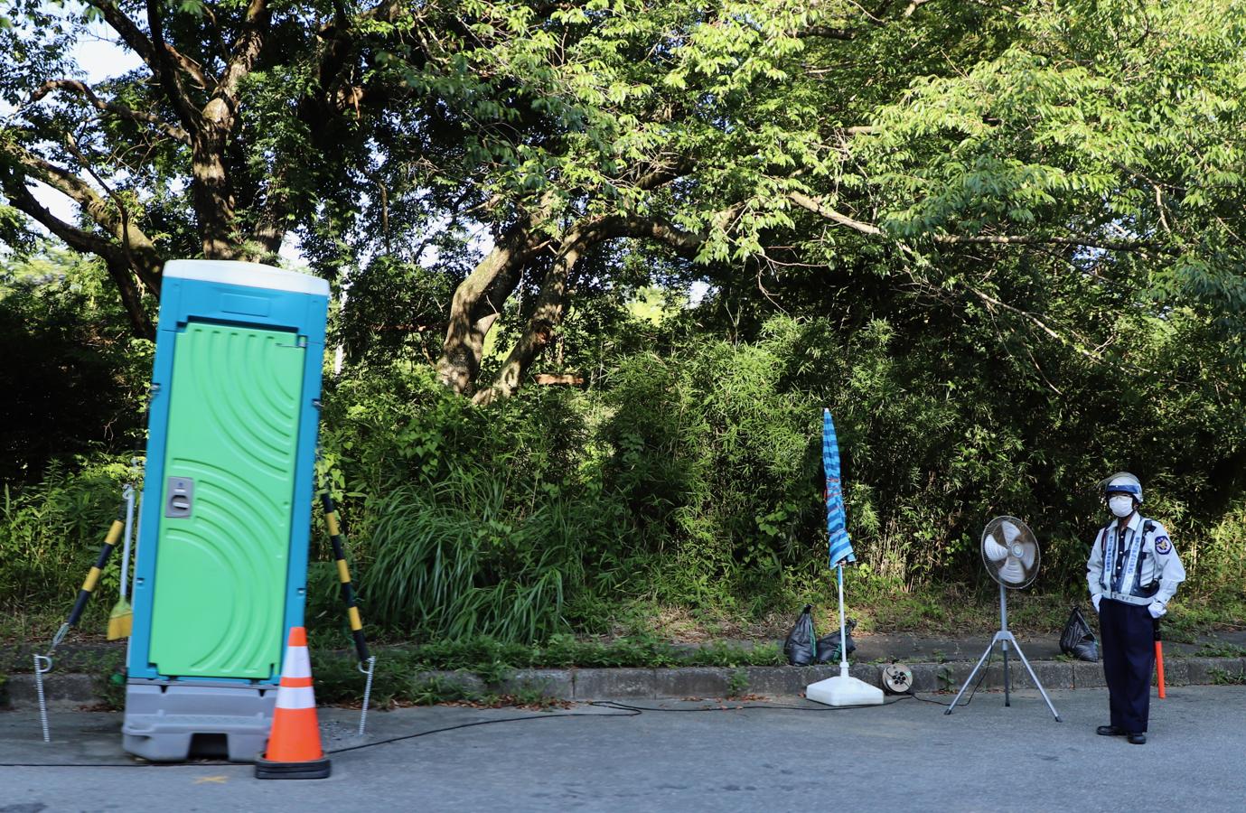 Con su propio retrete, una sombrilla y un ventilador, un guardia de seguridad vigila uno de los accesos cerrados a las áreas evacuadas alrededor de la central de Fukushima.. 