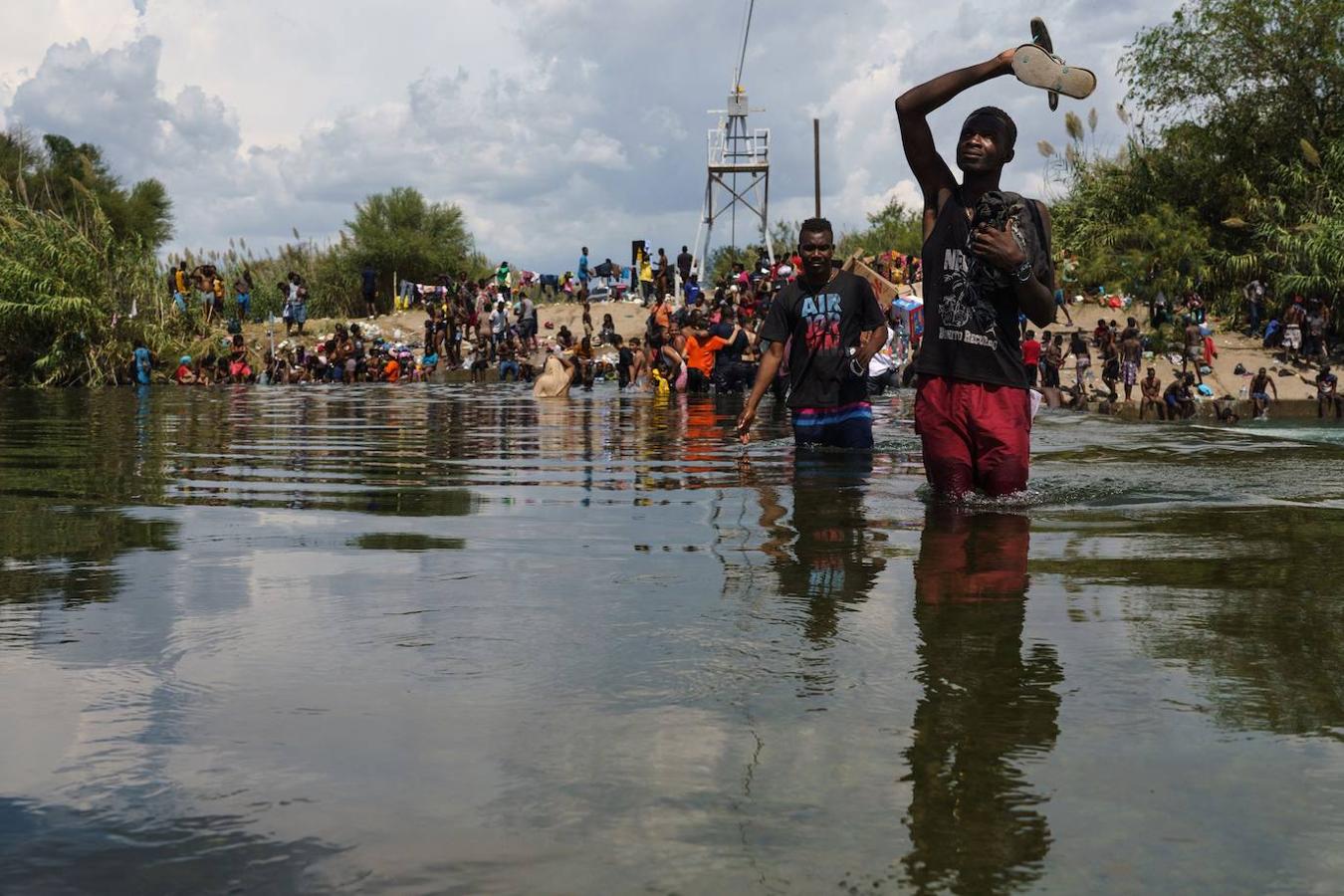 Un grupo de migrantes, muchos de ellos haitianos, cruzan el Río Bravo para obtener alimentos y suministros cerca de  México. 