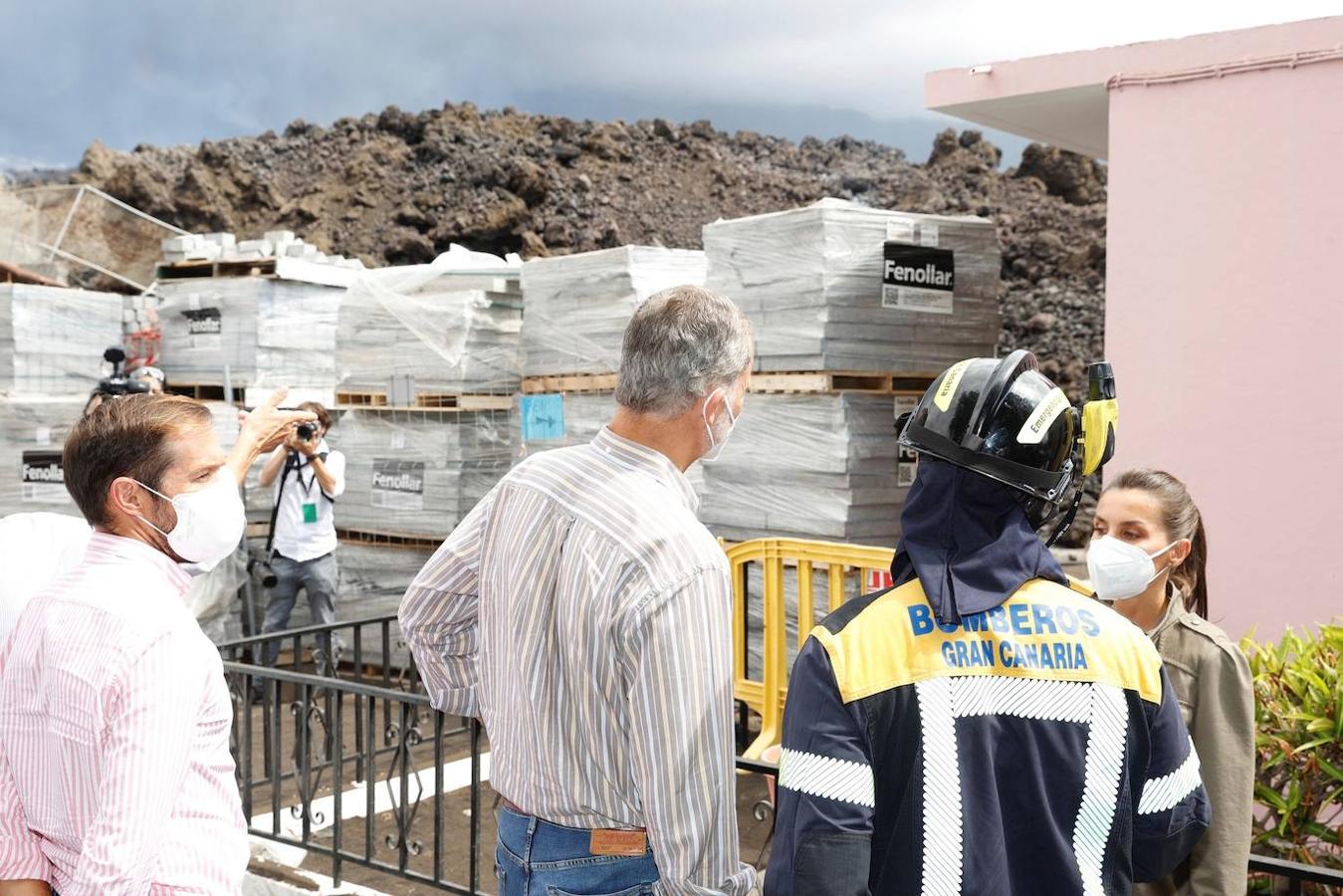 El rey Felipe y la reina Letizia conversan con un integrante del cuerpo de Bomberos durante su visita a la isla de la Palma para seguir conocer las zonas afectadas tras la erupción del volcán. 