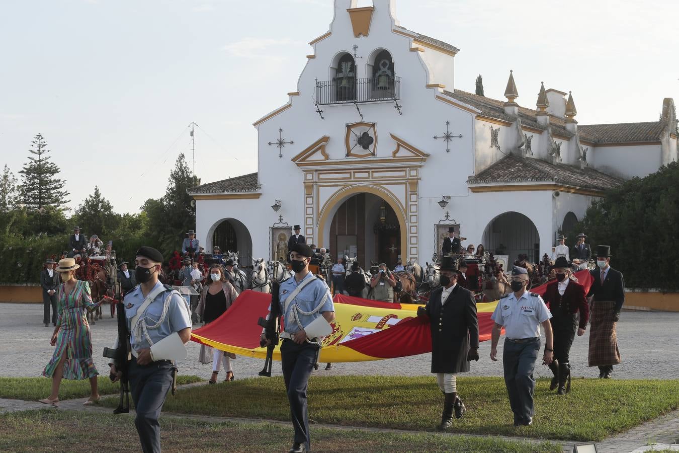 Izado de bandera en Tablada, con los carruajes participantes en el primer paseo por la ciudad.