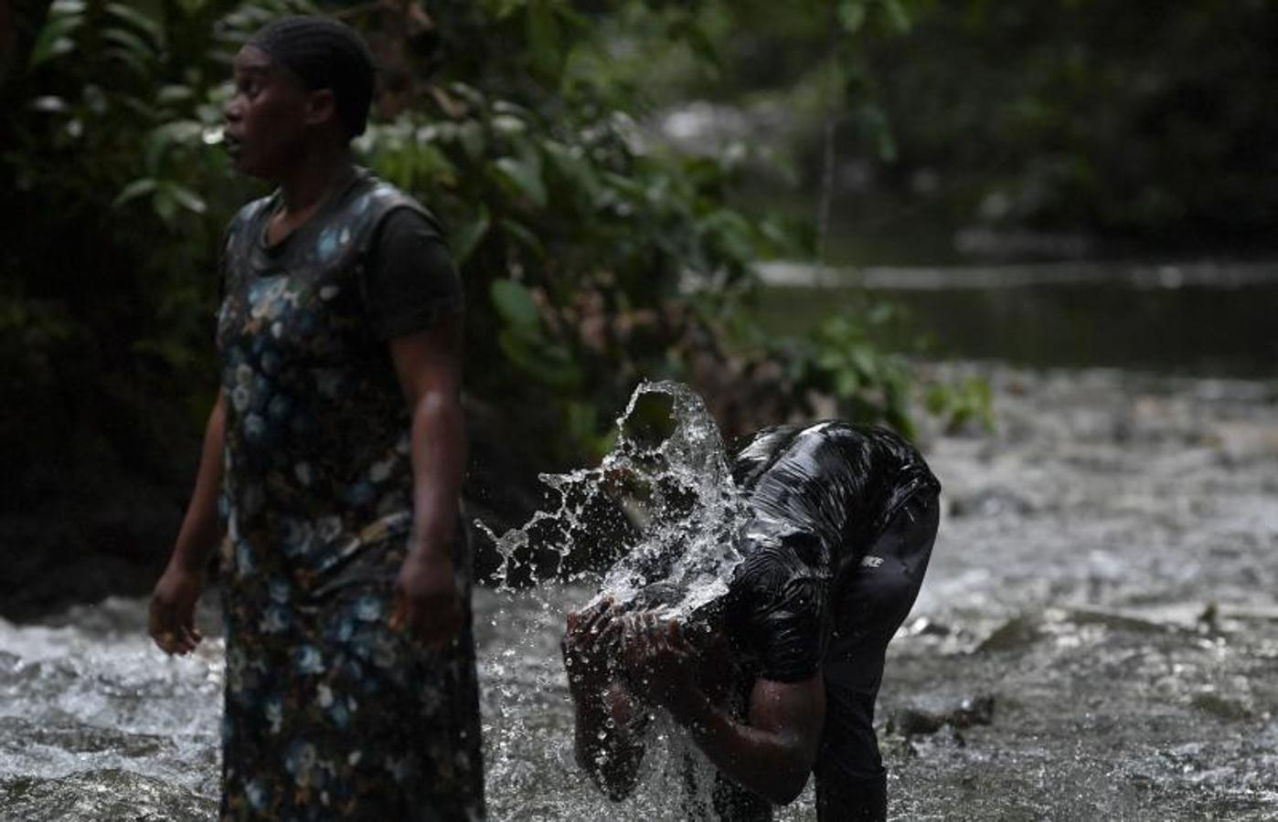 Los haitianos aprovechan el cauce de un río para refrescarse antes de continuar con la ruta hacia Panamá. 