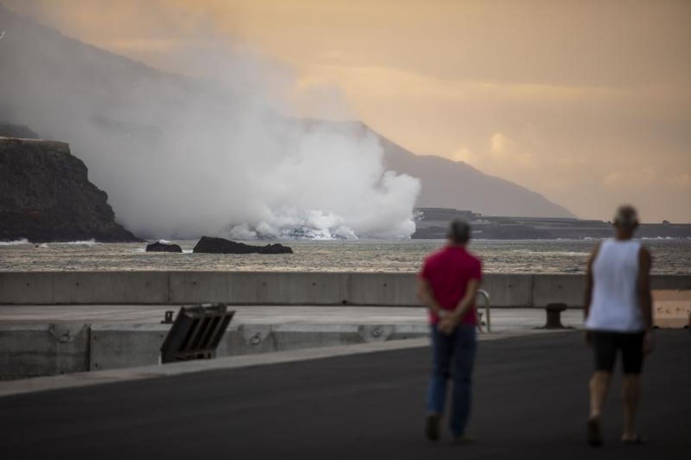 Dos palmeros observan la columna de humo debido al contacto del material incandescente con el agua. 