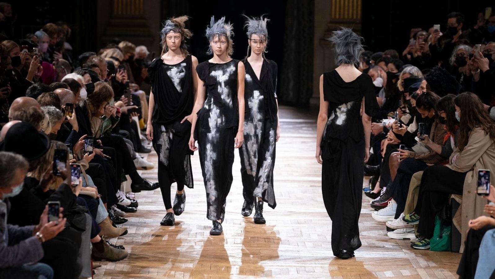 Yohji Yamamoto - PFW primavera-verano 2022. El negro en su versión más decadente ha teñido una propuesta donde la comodidad prima por encima de todo, aunque siempre marcando la silueta de la mujer de forma sensual gracias a drapeados, aberturas y asimetrías.