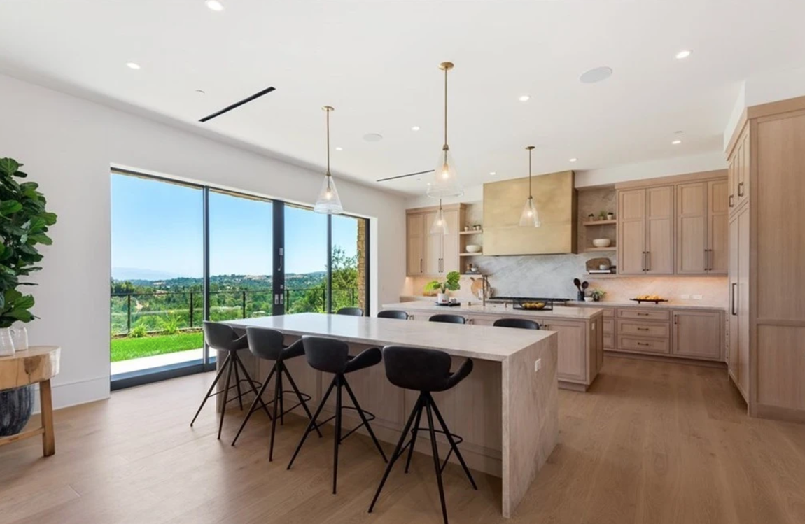 La nueva casa de Will Smith y Jada Pinkett. La cocina viene equipada con gabinetes de madera, encimeras de mármol, electrodomésticos de alta gama y dos islas, una con espacio extra de almacenaje y otra con una barra de desayuno con capacidad para hasta ocho personas. Esta estancia tiene salida directa al jardín.