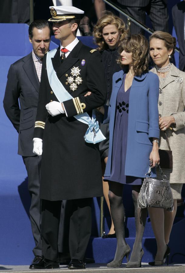 2007 - Los looks de la Reina Letizia en el Día de la Hispanidad. Eligió un sobrio vestido babydoll azul noche con escote en uve y apliques en el centro que combino con un abrigo ligeramente más claro de corte recto. Todo lo firma Felipe Varela.