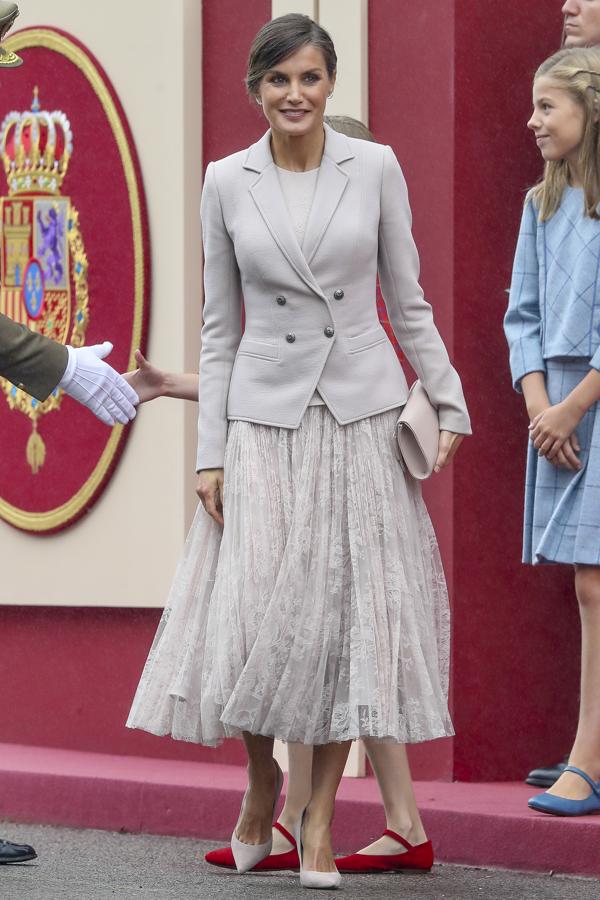 2018 - Los looks de la Reina Letizia en el Día de la Hispanidad. Hizo del gris perla su elección con un vestido vaporoso  firmado por Felipe Varela, de chantilly, cuyo cuerpo se ajustaba hasta la cadera al que añadió una blazer del mismo tono con botones palteados. Añadió unos salones y clutch de Magrit a juego.