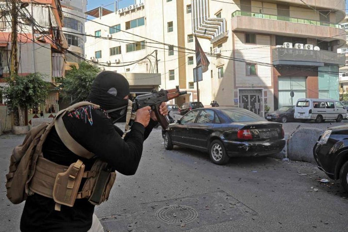 Un miliciano de Hizbolá y Amal apunta con un fusil de asalto en Tayouneh, en la capital libanesa. 