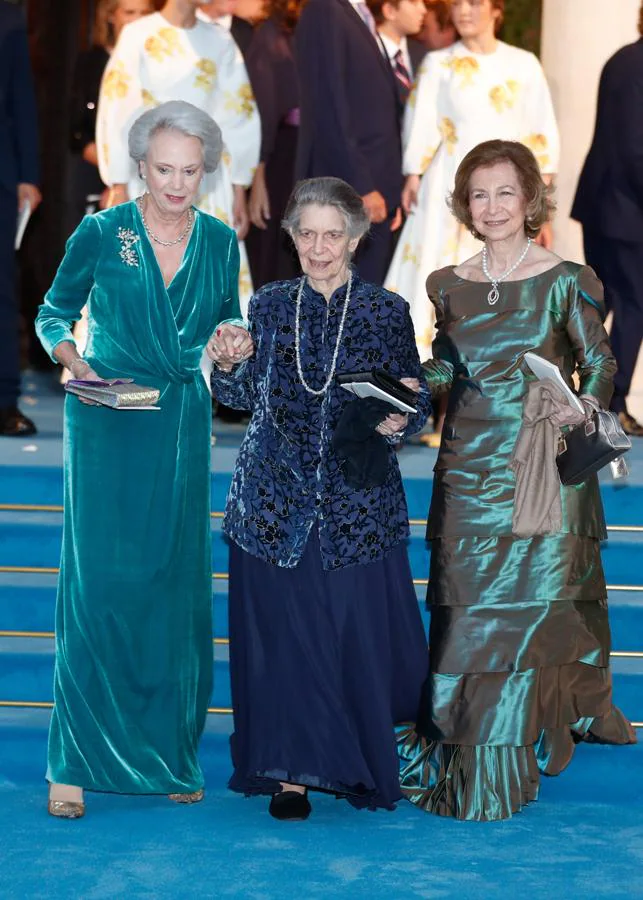 La Reina Sofía con Irene de Grecia y Benedicta de Dinamarca. La Reina emérita lució un diseño verde irisado compuesto por varias hileras de volantes con los hombros ligeramente marcados y manga larga al que añadió un colgante con una gran esmeralda y perlas.