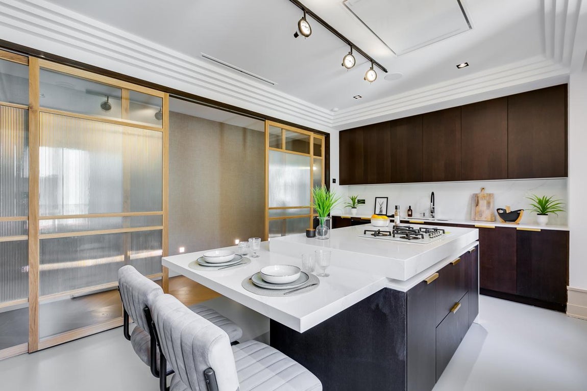 Las puertas de este lujoso piso de Serrano, se abren para recibir a su nuevo propietario. La cocina es muy amplia y cuenta con una pared con una puerta corredera con cristales traslúcidos que le dan un aire más sofisticado.