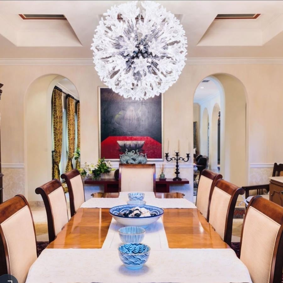 La lujosa mansión de Chábeli Iglesias en Miami. El salón principal comunica con otro comedor, donde el estilo clásico se basa en líneas sencillas con una paleta de colores neutros donde hay ciertos detalles más modernos -como la lámpara o los cuencos- que crean un contraste muy interesante.