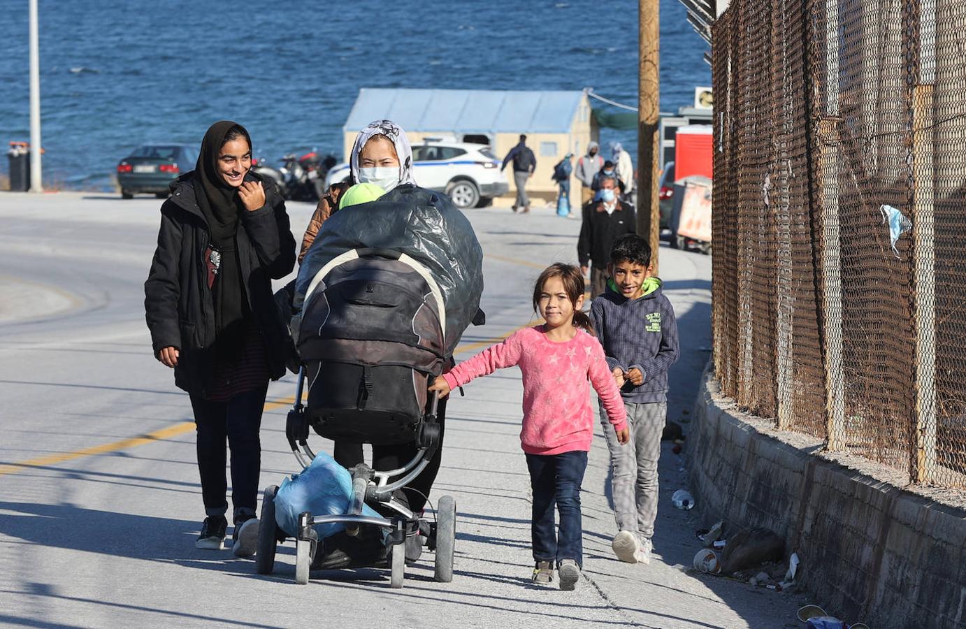 Dos mujeres pasean con sus hijos junto al campo de refugiados. 