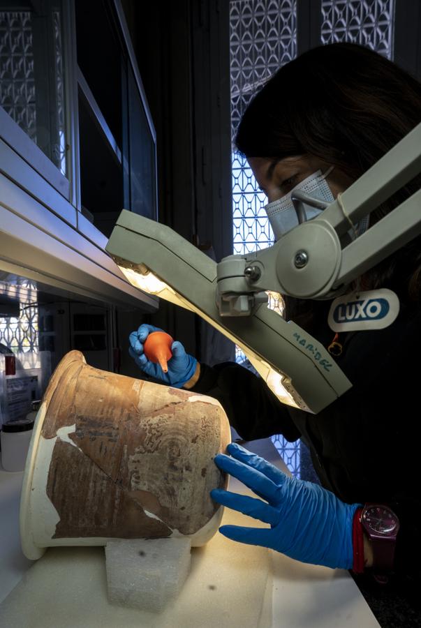 María Turégano ante una cerámica ibérica llegada desde el Museo Arqueológico Nacional y restaurada en los años 40, que está revisando. Ha decidido no intervenir en una de las partes decoradas ante el peligro de dañar el dibujo. 