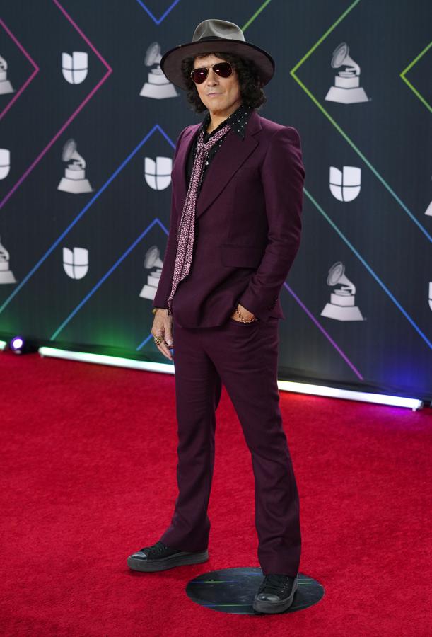 Enrique Bunbury - Alfombra roja de los Grammy Latinos 2021. Lució un traje burdeos ajustado con el pantalón ligeramente acampanado y lo combinó con un pañuelo con tonos similares. No faltaron tampoco su inseparable sombrero y las gafas de aviador.