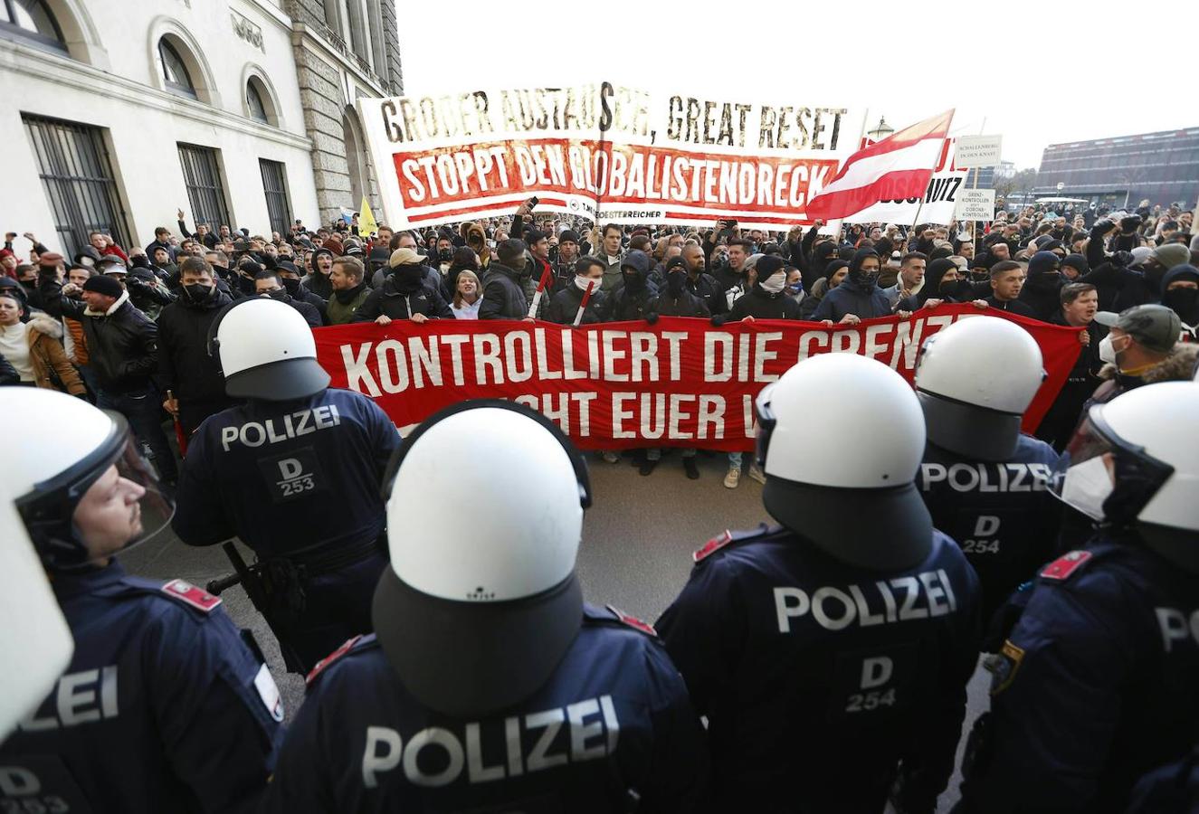 Varios policías montan guardia mientras la gente marcha por la Heldenplatz durante una protesta contra las restricciones en todo el país. 