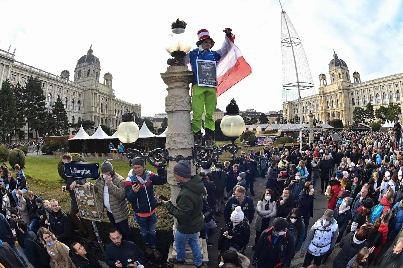 Un manifestante se cuelga de una farola durante las manifestaciones contra las medidas tomadas para frenar la pandemia del coronavirus. 