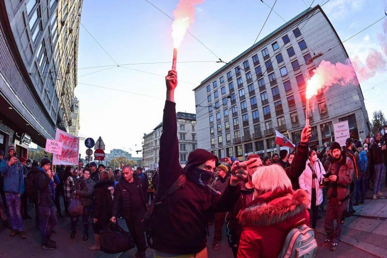 Algunas de las personas que han participado en la manifestación contra las nuevas medidas sanitarias han encendido bengalas durante las protestas. 