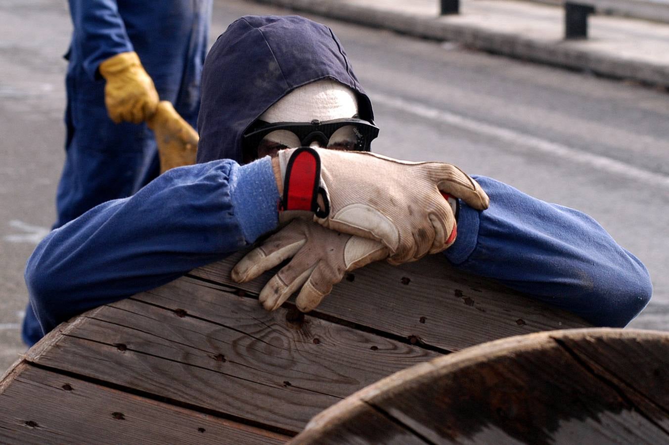 Un trabajador del sector naval espera el embate de las cargas policiales parapetado en una barricada. 