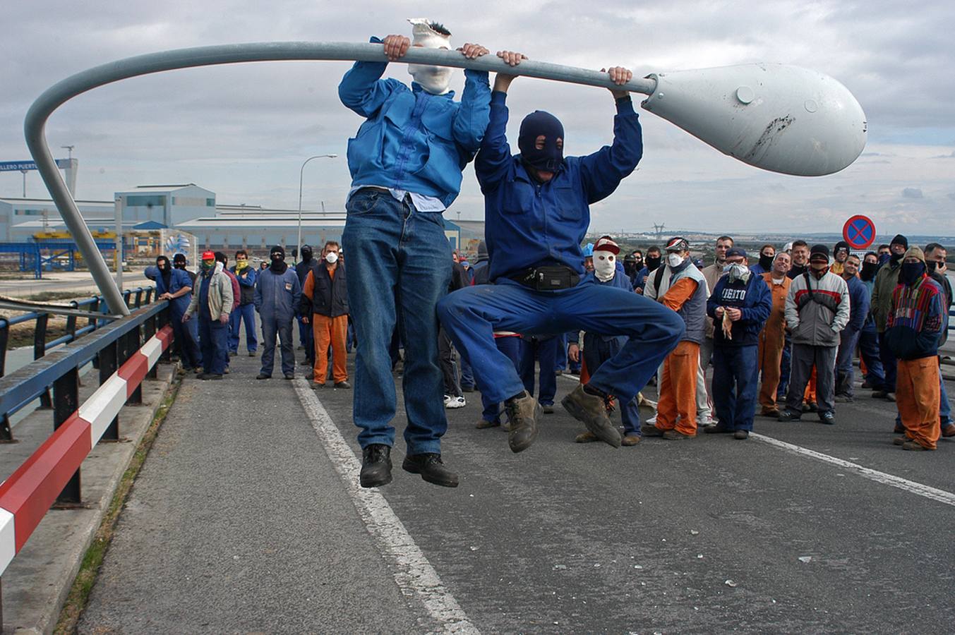 Dos manifestantes derriban una farola en uno de los muchos destrozos sufridos en el Puente Carranza a lo largo de décadas. 