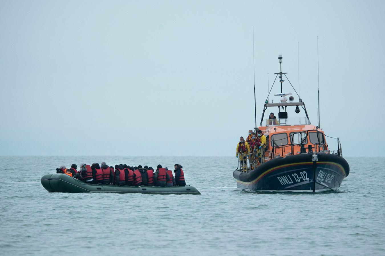 Los migrantes son ayudados por el bote salvavidas RNLI antes de ser llevados a una playa en Dungeness, al sur de Inglaterra. 