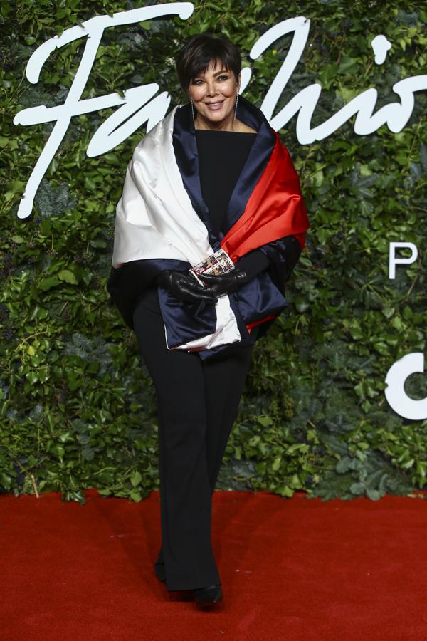 Kris Jenner - Alfombra roja de los British Fashion Awards. Optó por un 'total look black' al que añadió una capa satinada. Todo de Tommy Hilfiger.