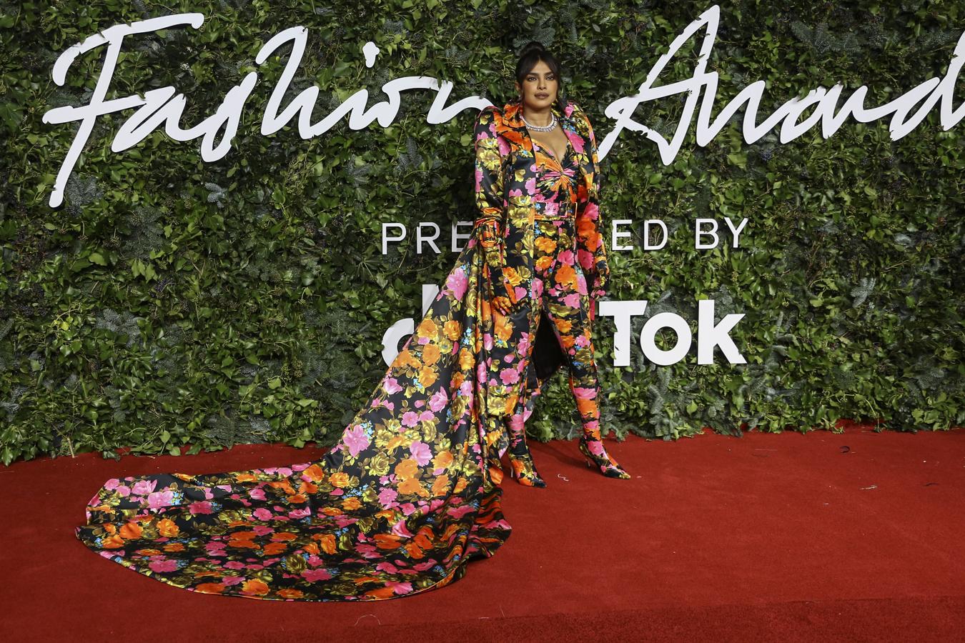 Priyanka Chopra - Alfombra roja de los British Fashion Awards. Fue una de las más coloridas de la noche con un mono floreado de Richard Quingg que fusionaba los botines con el pantalón jugando con el efecto 'pierna infinita' y que terminaba con una gran capa con el cuello muy marcado.