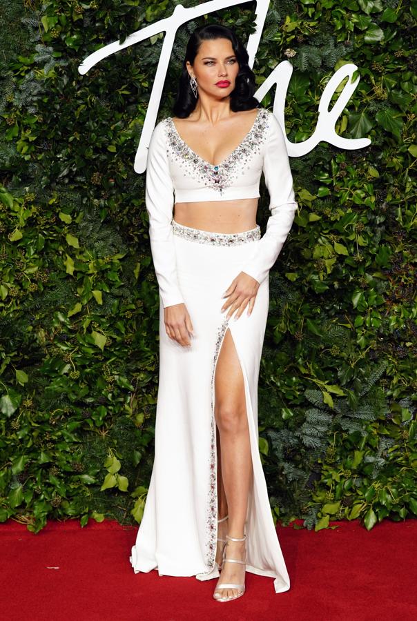 Adriana Lima - Alfombra roja de los British Fashion Awards. Muy sugerente con un dos piezas de la diseñadora griega Celia Kritharioti compuesto por un crop top con pronunciad escote en uve que poseía una cenefa de lentejuelas, y una falda con una amplia abertura frontal.