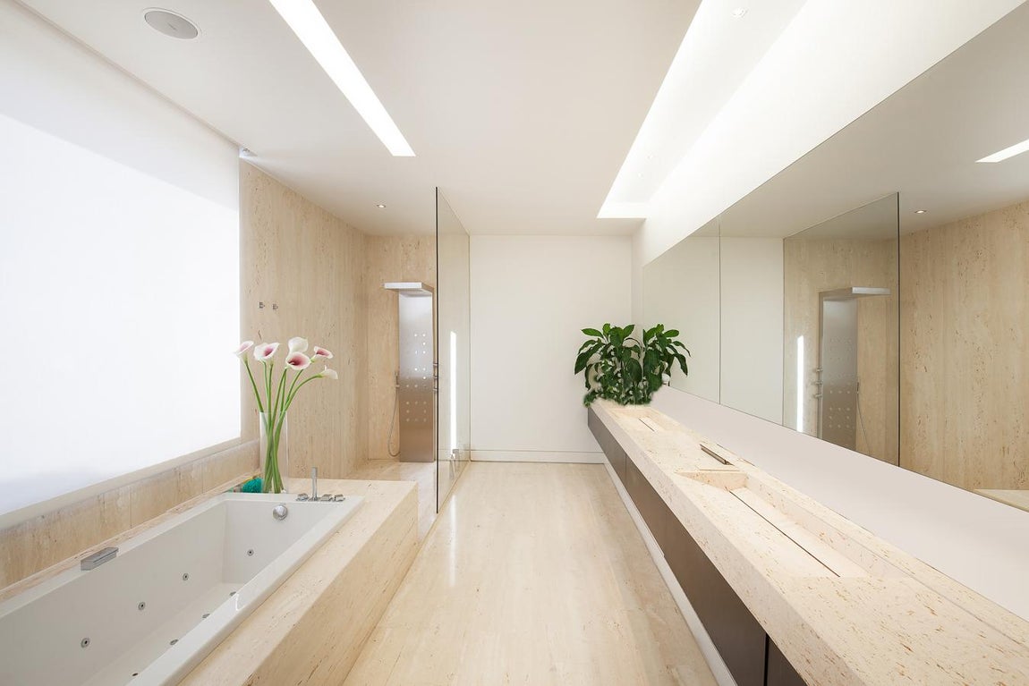 La exclusiva propiedad de La Moraleja para vivir rodeado de lujos. El baño del dormitorio principal consta de una ducha de gran tamaño y una bañera con hidromasaje además de un tocador doble. Todo ello bajo una estética minimalista muy sofisticada.