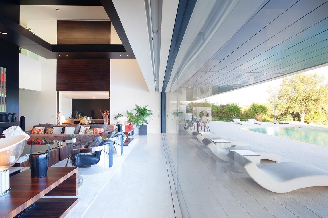 La exclusiva propiedad de La Moraleja para vivir rodeado de lujos. El salón principal presenta los techos de madera de roble, así como algunas de las paredes, que contrastan con el gres del pavimento. El mobiliario por su parte combina piezas de estilo retro con otras más vanguardistas en donde no faltan obras de arte de reconocidos artistas que le confieren el toque diferenciador.