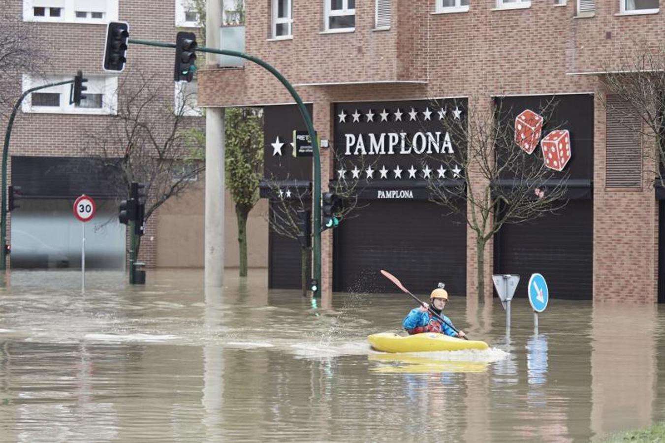 Un hombre con una canoa en una vía inundada del barrio de Rotxapea, en Pamplona. 