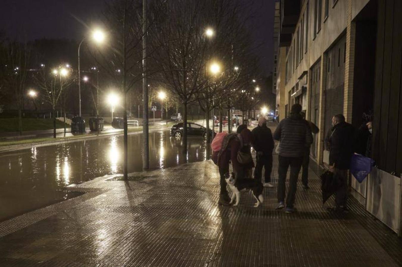 Vecinos afectados por el corte de luz debido al desbordamiento del río Arga se reúnen en la puerta de su portal