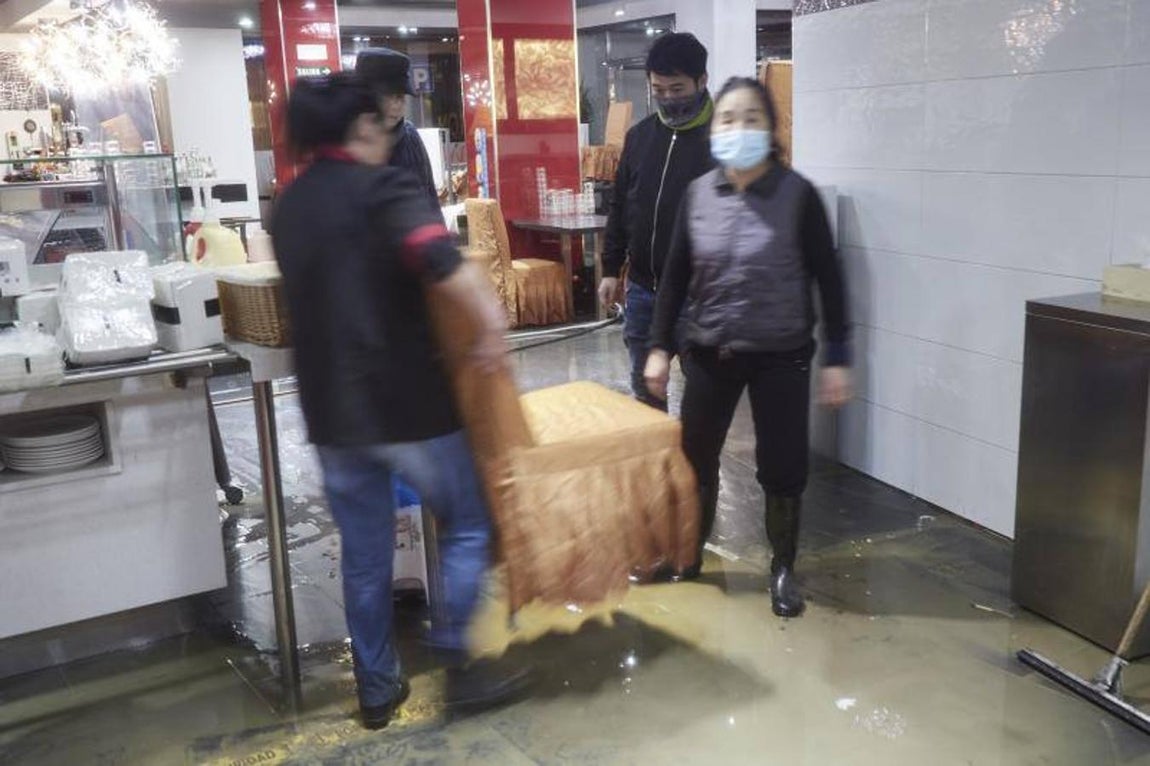 Trabajadores y la dueña del restaurante WOK de la Rotxapea (Barrio de Pamplona) limpian y organizan el restaurante tras el desbordamiento del río Arga