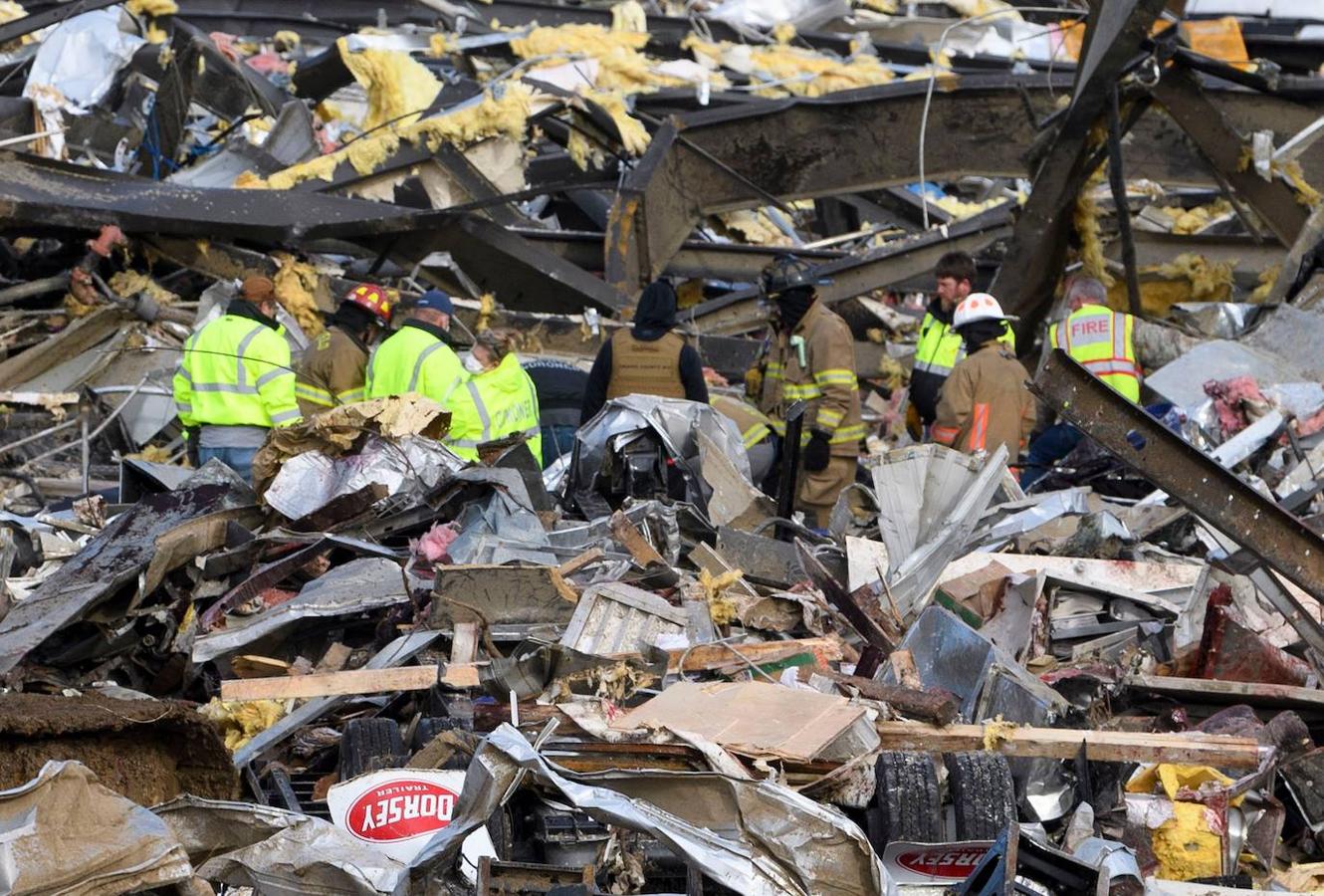 Los trabajadores de emergencia registran lo que queda de la fábrica de velas de productos de consumo Mayfield después de que fuera destruida por un tornado en Mayfield, Kentucky, el 11 de diciembre de 2021. 