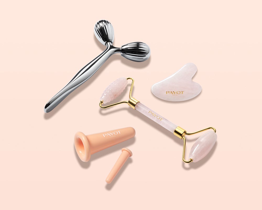 Gadgets beauty Face Moving de Payot. Accesorios profesionales de masaje facial en casa para potenciar las cremas y relajar la piel. Se puede elegir entre el Lifting Facial Gua Sha (26,50 €) de cuarzo rosa, el rodillo remodelante Sculpting Facial Quartz Roller (29,50 €), también de cuarzo rosa, las copas alisadoras Smoothing Face Cups (9,90 €), inspiradas en medicina tradicional china y fabricada en silicona, y el rodillo de zinc Revitalizing Facial Roller (44 €), para rostro, cuello y escote.