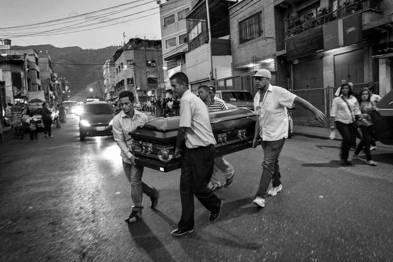 Varios familiares de Fredy Guerrero trasladan el féretro del muerto por las calles del barrio de Catia. El joven de 25 años fue ejecutado por la policía tras ser capturado durante el asalto a una casa de un barrio acomodado de Caracas. Todos fueron torturados antes de ser ejecutados. Las autoridades tardaron siete días en entregar los cuerpos. 