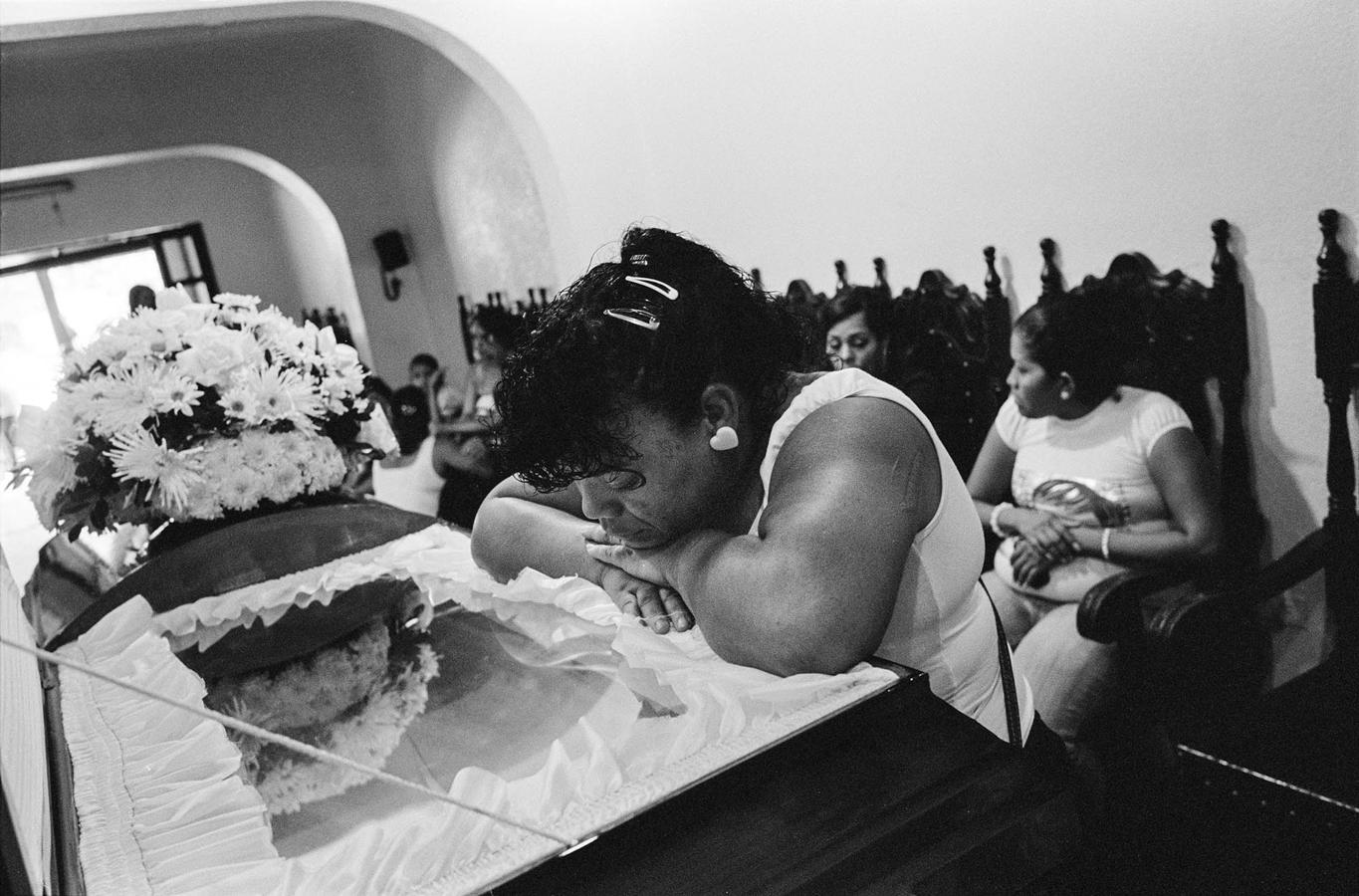 Una mujer llora durante el funeral en noviembre de 2009 de un hombre que fue asesinado con dieciséis disparos en la cabeza por uno de los 'colectivos' de Caracas. 