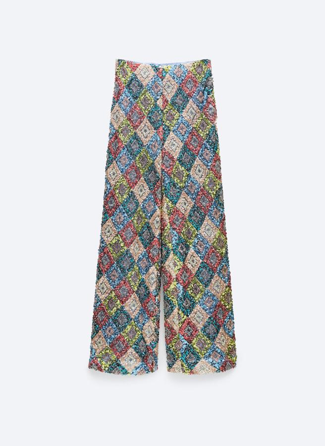 Pantalón con motivos multicolor realizado en tejido de lentejuelas, con cierre lateral de Uterqüe (119€)