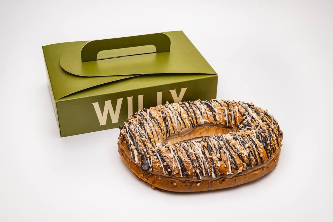 Willy Factory. Willy Factory presenta para el Día de Reyes cuatro roscones, todos ellos en formato maxi, para compartir en familia, y mini, ideal para parejas y singles: el original con toque de limón, el de crema con topping de red velvet y perlas blancas, el relleno de nata cubierto de almendras y azúcar y uno de trufa con virutas de chocolate, perlas blancas y avellanas. «Tanto la masa como los rellenos y las coberturas se preparan solo con ingredientes frescos sin ultraprocesados ni aditivos, con una selección de trigos nacionales de máxima calidad y de elevado nivel proteico y con un contenido reducido de grasas y azúcares, inferior al 15 %», presumen. Cuatro tiendas en Madrid.