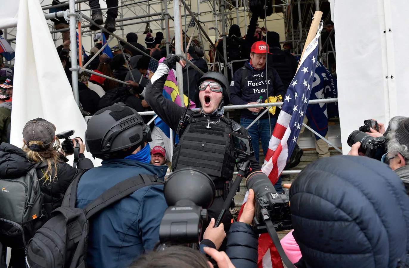 La prensa fotografía a un hombre que jalea a la muchedumbre animándolos a entrar en el Capitolio. 