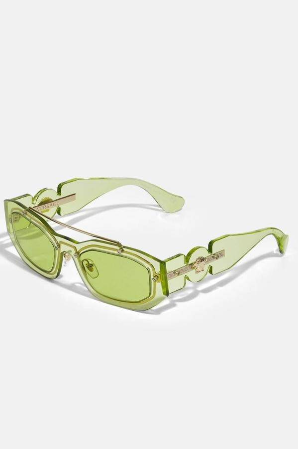 Versace - Prendas y accesorios para sucumbir al verde con estilo. Gafas de sol con montura  y cristales verde transparente, de inspiración retro, de Versace. Precio: 244€.