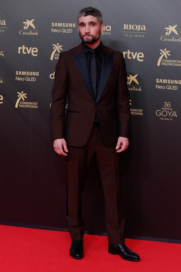 Jesús Salgado - Los looks masculinos de los Goya 2022. Fue uno de los pocos que huyó del negro con un traje de chaqueta satinado de color borgoña con las solapas negras de Hugo Boss al que añadió unos mocasines de Martinelli.