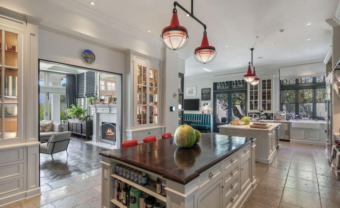 La mansión que Calvin Harris vende por 25 millones. La cocina comunica con el salón y a diferencia del resto de estancias, tiene el suelo de piedra. Una gran isla central de madera se hace con el protagonismo y sirve como nexo de unión entre el salón, la cocina y el comedor.