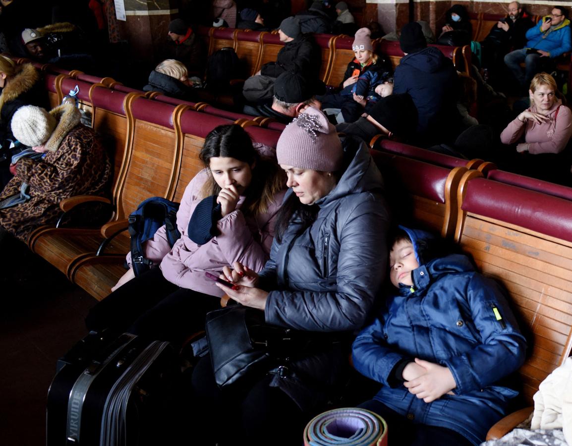 Una mujer y sus hijos descansas en la estación de tren de Leópolis. 